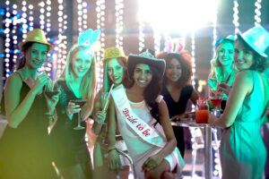 Eine Gruppe Mädels mit verrückten Hüten feiert einen Junggesellinnenabschied