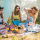 Drei Frauen bei einem Picknick sitzen auf einer Decke